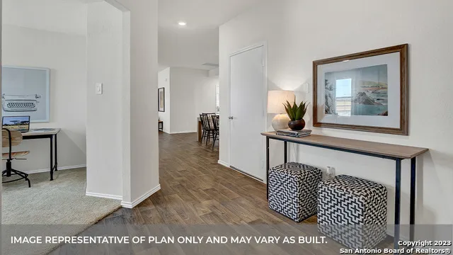 a view of a hallway to a livingroom with furniture