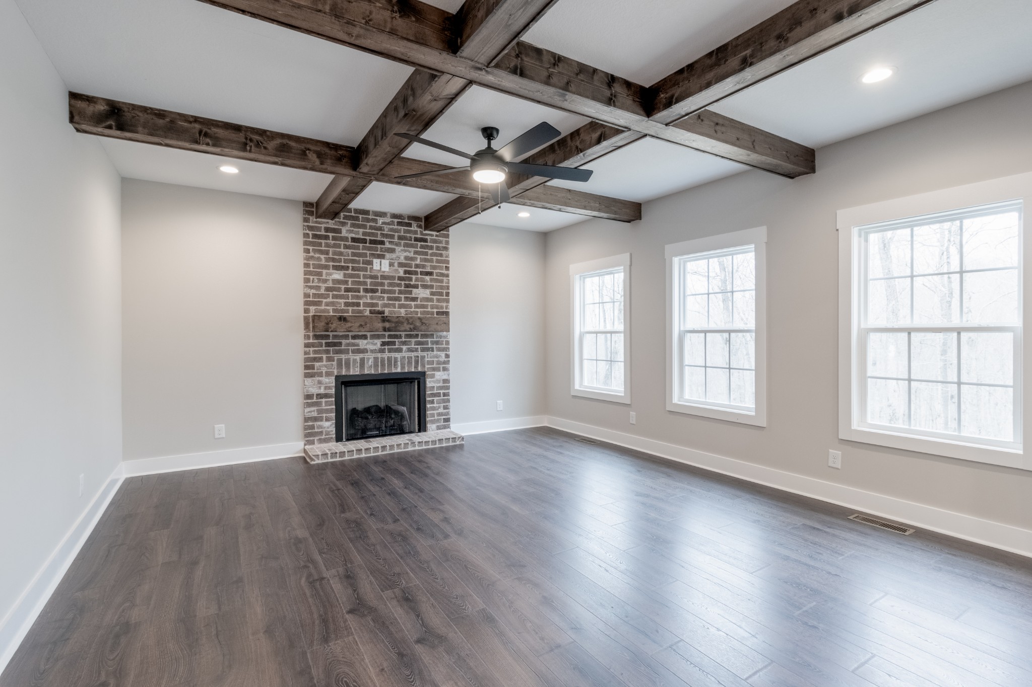600 Swift Lane Cunningham, TN 37052 - Photo 4 of 38 an empty room with wooden floor fireplace and windows