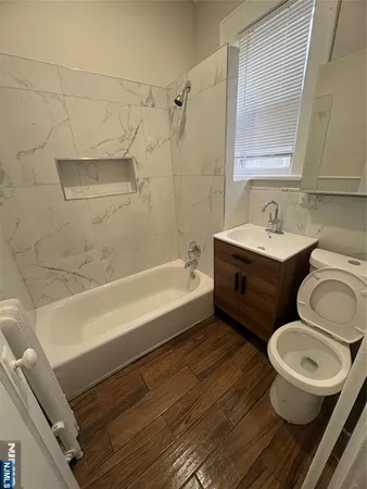 a bathroom with a granite countertop toilet sink and mirror