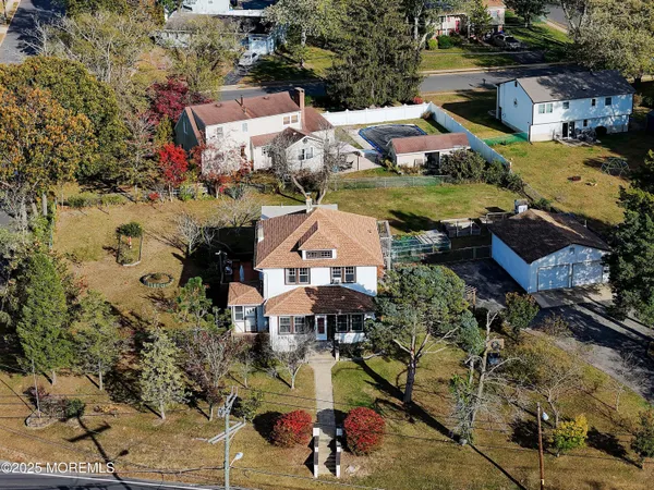 an aerial view of a house with a garden and lake view