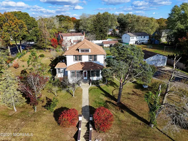 an aerial view of a house with a yard and lake view