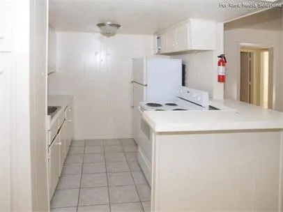 a kitchen with refrigerator and cabinets
