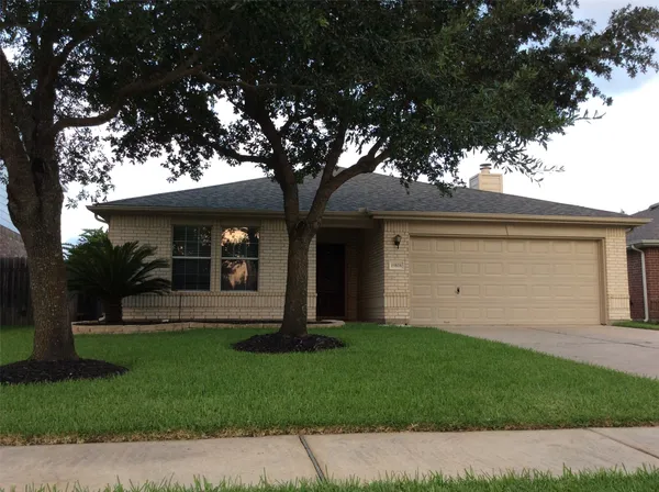 a front view of a house with a garden and yard