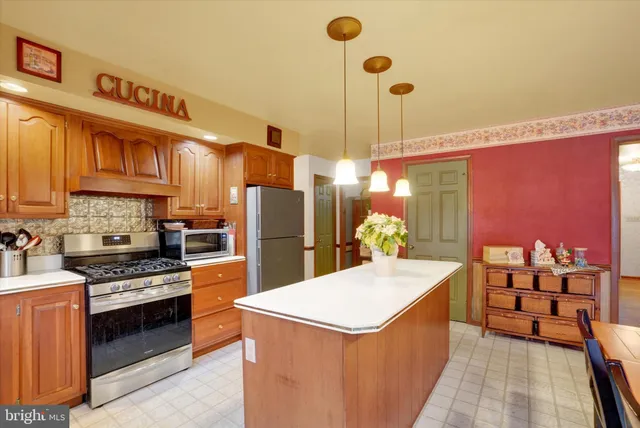 a kitchen with stainless steel appliances a stove a sink refrigerator and cabinets