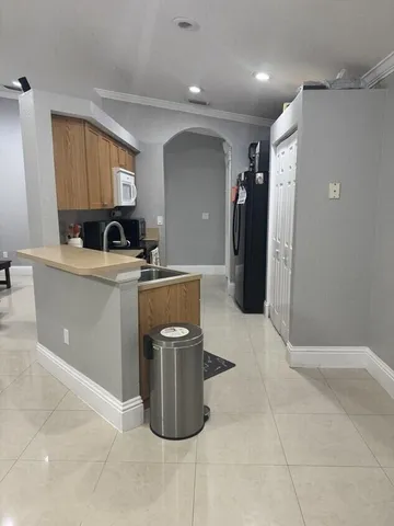 a kitchen with a sink a refrigerator and cabinets