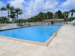 a view of a swimming pool with a patio and a yard