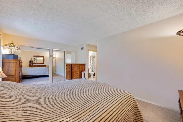 a bathroom with a granite countertop toilet sink and mirror