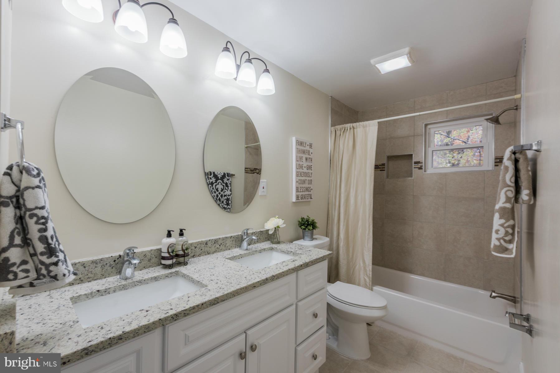 3812 Collier Road Randallstown, MD 21133 - Photo 15 of 27 a bathroom with a granite countertop toilet sink and mirror