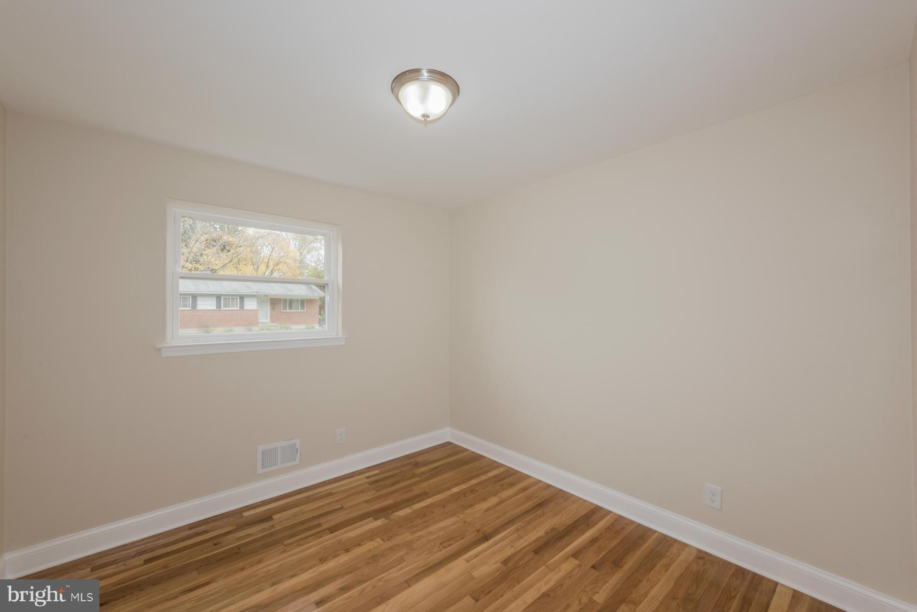 3812 Collier Road Randallstown, MD 21133 - Photo 18 of 27 a view of an empty room with wooden floor and a window