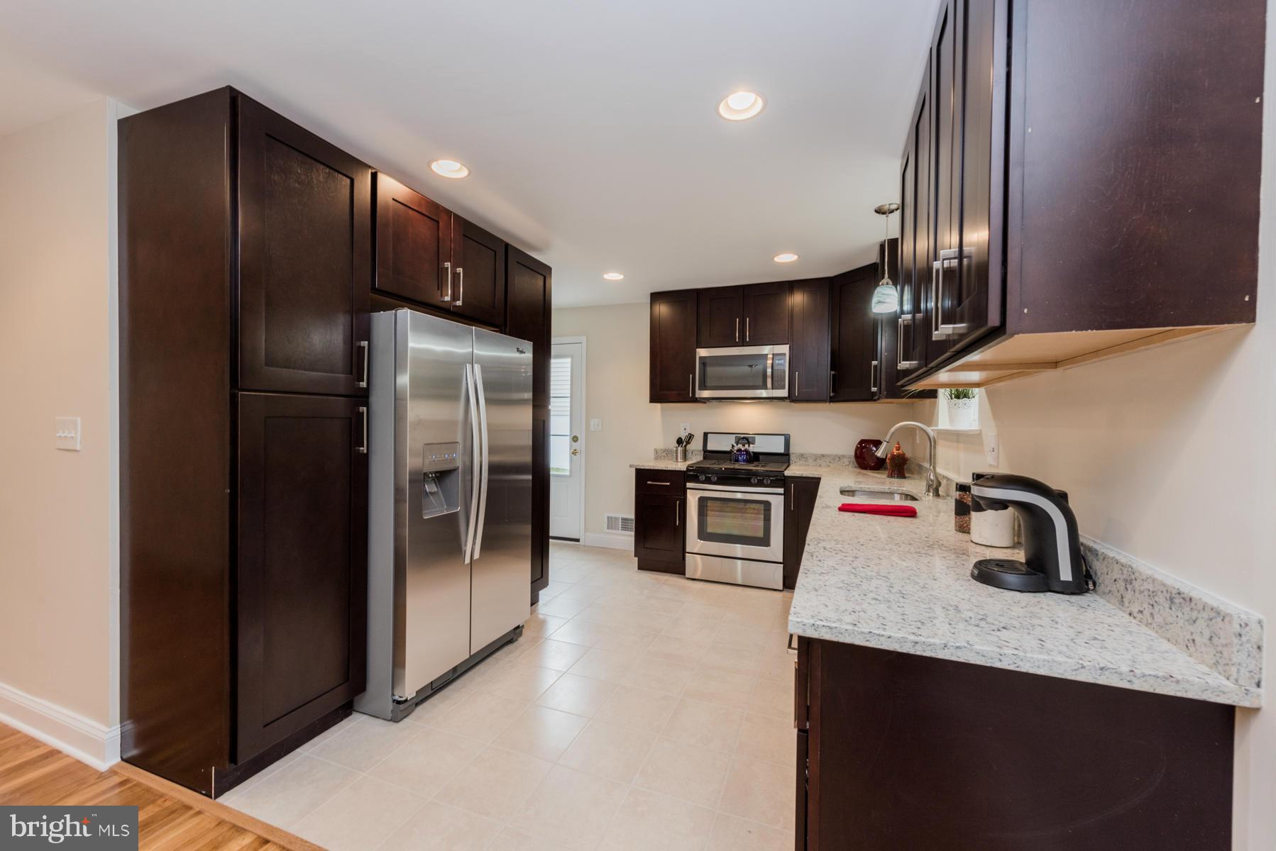 3812 Collier Road Randallstown, MD 21133 - Photo 8 of 27 a kitchen with stainless steel appliances granite countertop a refrigerator and a sink