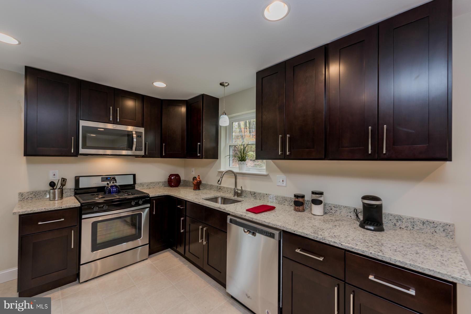3812 Collier Road Randallstown, MD 21133 - Photo 9 of 27 a kitchen with stainless steel appliances granite countertop a sink stove and microwave