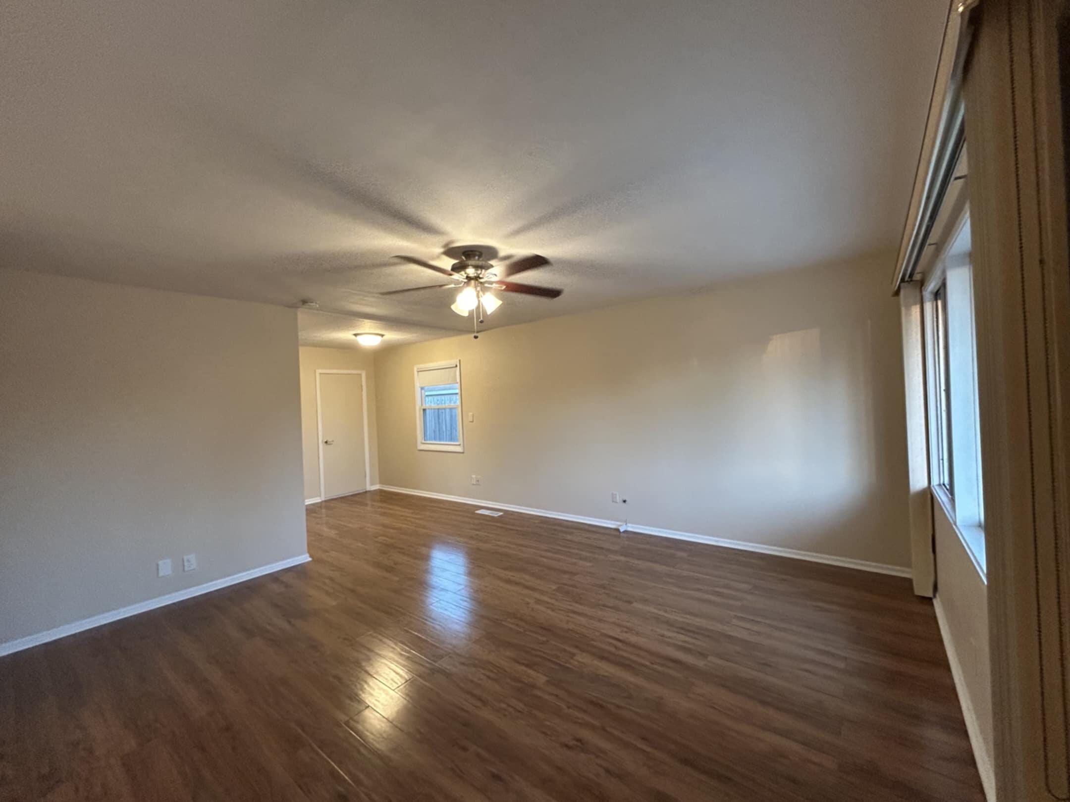 3339 176th Place Hammond, IN 46323 - Photo 3 of 16 an empty room with wooden floor fan and windows