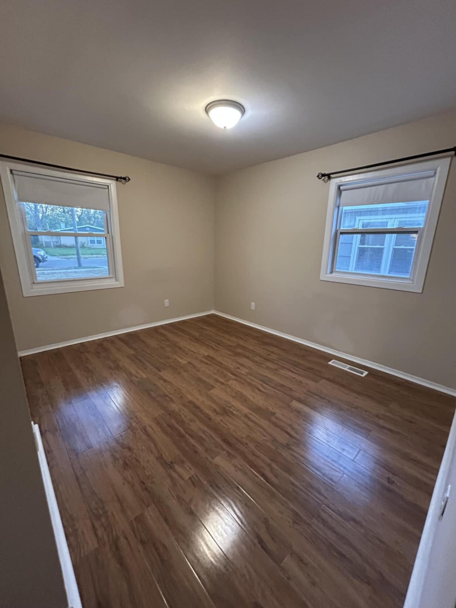 3339 176th Place Hammond, IN 46323 - Photo 10 of 16 a view of an empty room with wooden floor and a window
