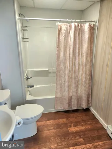 a bathroom with a toilet and a shower curtain