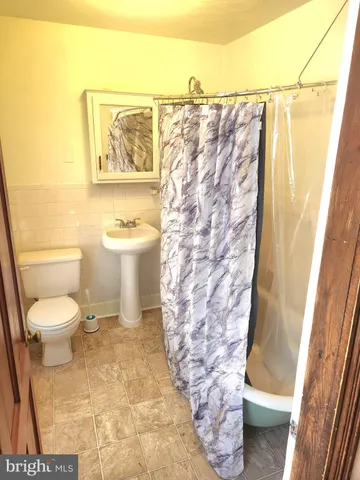 a bathroom with a toilet and a shower curtain