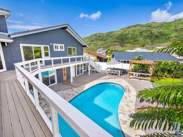 a view of a house with pool and chairs