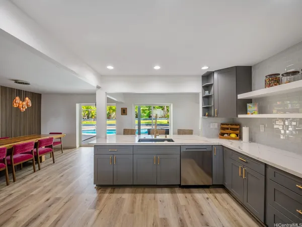 a kitchen with stainless steel appliances granite countertop a sink and wooden floors