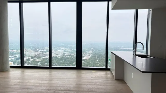 an empty room with windows and view of balcony