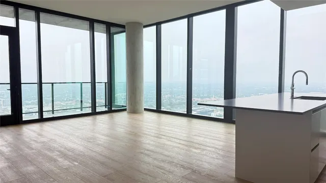 a view of a room with wooden floor and windows