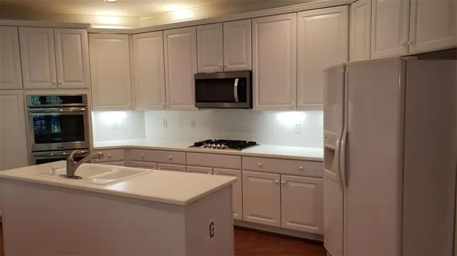a kitchen with white cabinets and stainless steel appliances