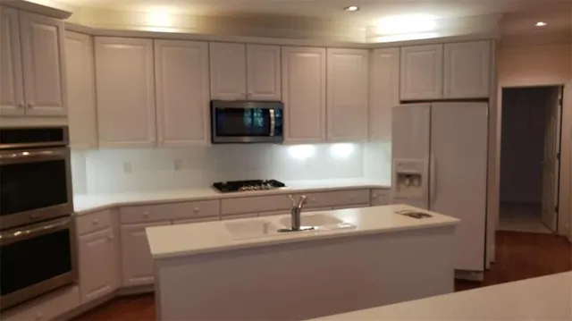 a kitchen with stainless steel appliances a sink a stove a microwave and refrigerator