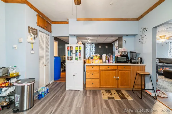 a room with lots of white furniture a chandelier and a view of living room