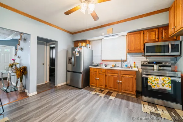 a kitchen with stainless steel appliances granite countertop a refrigerator a stove top oven a sink and dishwasher