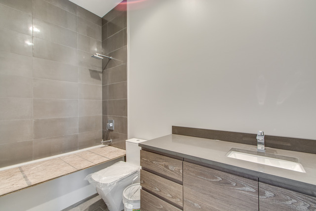 2042 West Rice Street, Unit 3 Chicago, IL 60622 - Photo 14 of 19 a bathroom with a granite countertop sink a toilet and bathtub