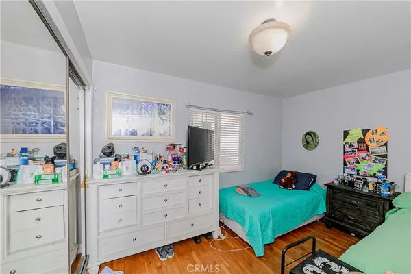 a bedroom with a bed window and dresser