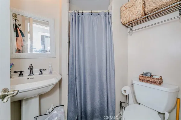 a bathroom with a sink a toilet and a mirror