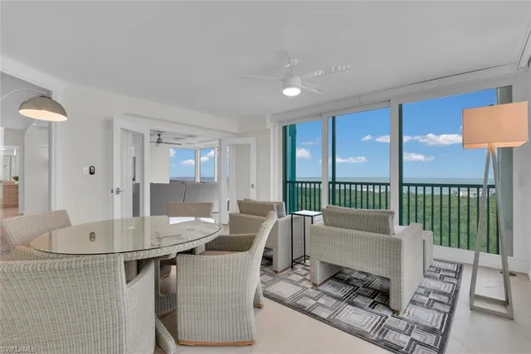 a living room with furniture and a floor to ceiling window