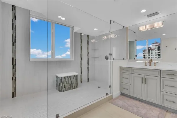 a spacious bathroom with a toilet sink shower and mirror