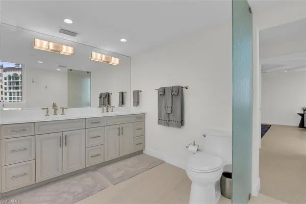 a bathroom with a double vanity sink toilet and shower