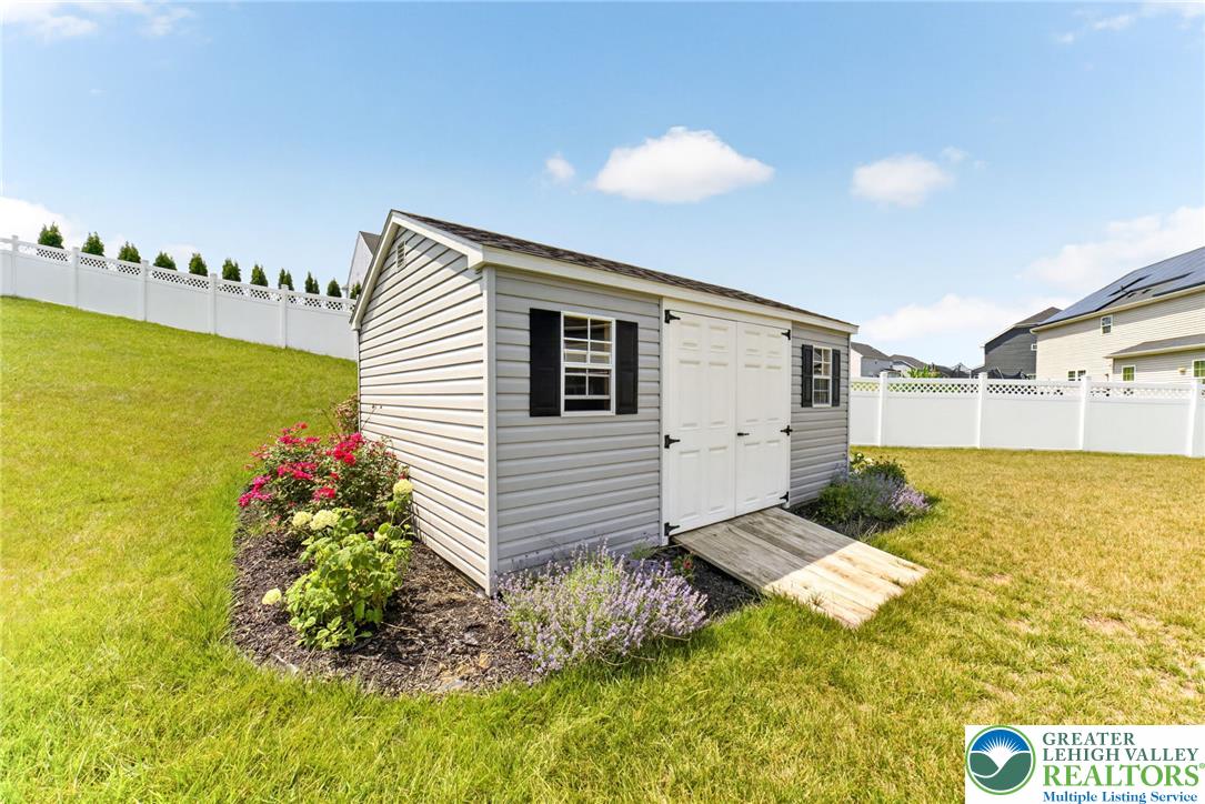 3952 Orth Street Bethlehem, PA 18020 - Photo 51 of 60 A well-maintained storage shed stands amidst a vibrant garden patch, offering practical utility and charming curb appeal.