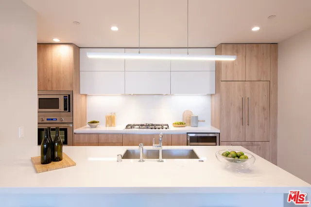 a kitchen with a sink appliances and cabinets
