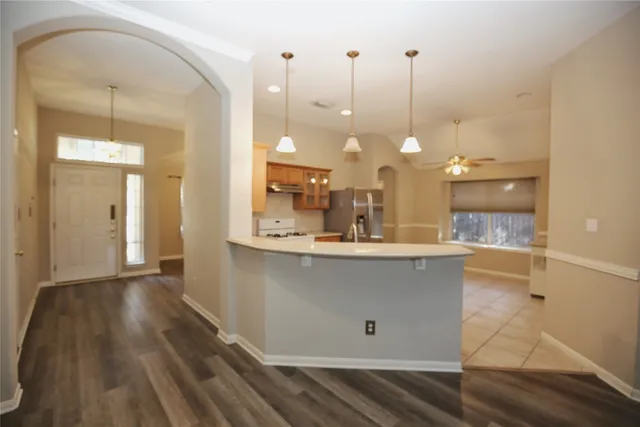 a view of a kitchen with kitchen island white cabinetry and a chandelier