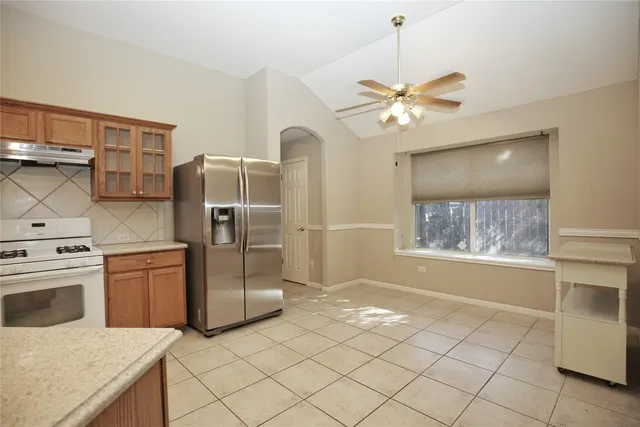 a kitchen with stainless steel appliances a stove a refrigerator and white cabinets