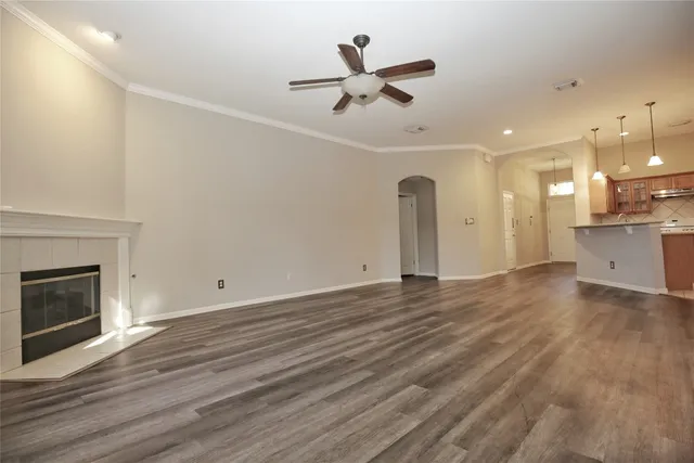 an empty room with wooden floor and a fireplace