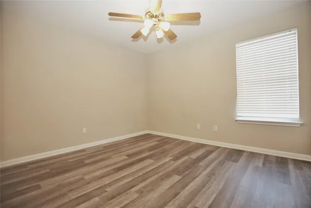 an empty room with a window and a fan