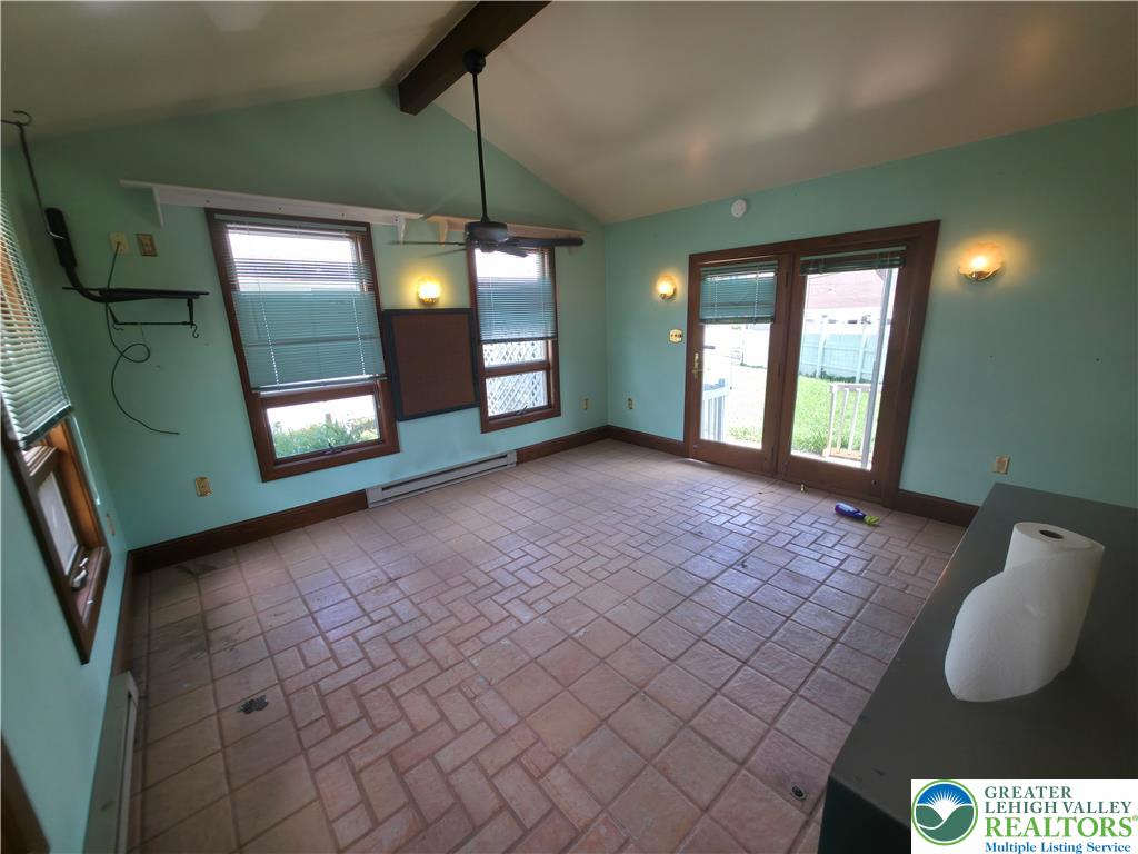 719 Keystone Avenue Bethlehem, PA 18018 - Photo 26 of 32 A well-lit bonus room features a vaulted ceiling, brick-patterned tile flooring, and exterior access.