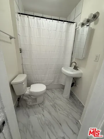 a bathroom with a toilet a sink and a shower