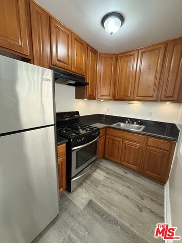 a kitchen with granite countertop wooden cabinets and stainless steel appliances