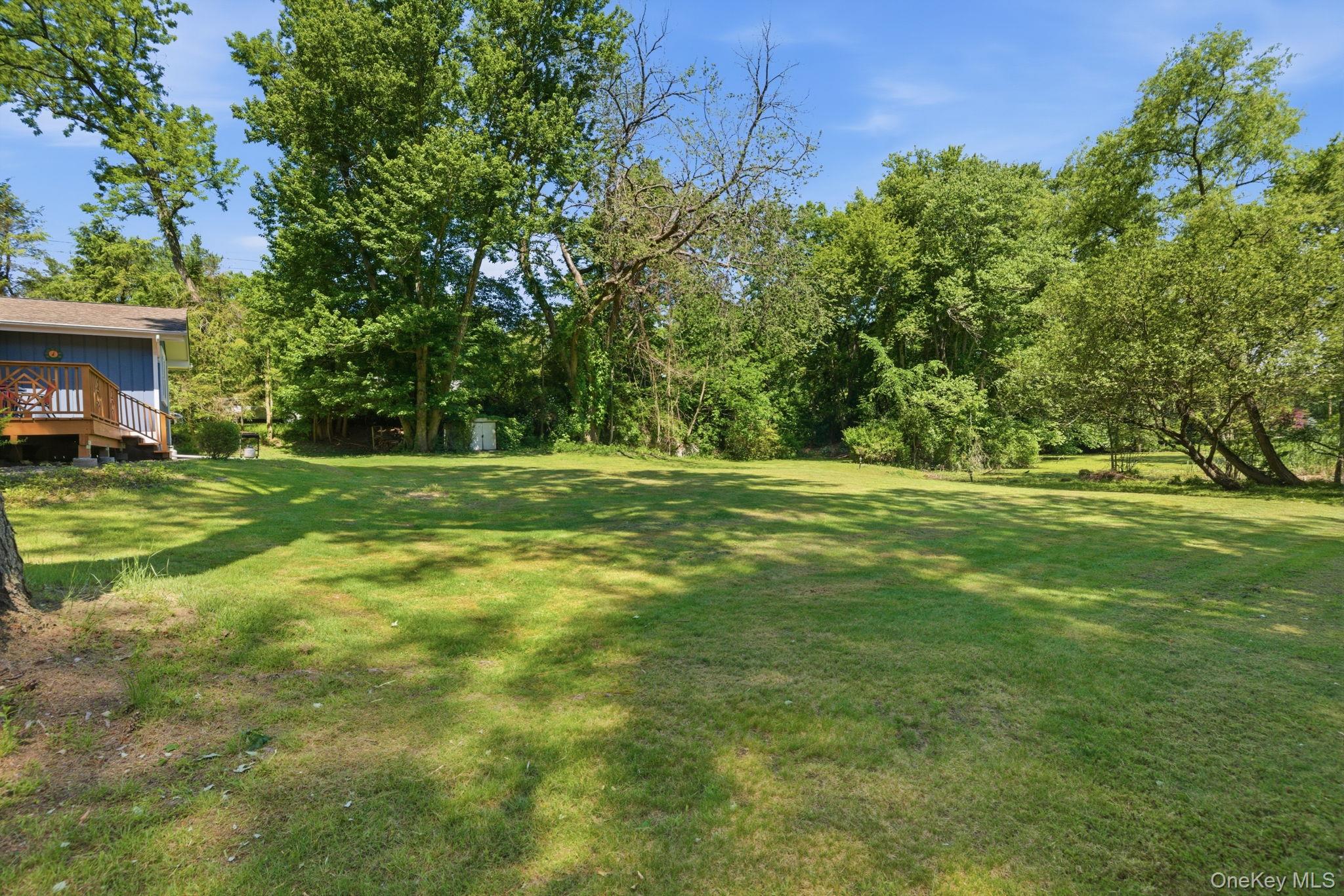 35 Deans Bridge Road Somers, NY 10589 - Photo 28 of 49 Level, open lawn runs from the side of the home to a mature wooded border, the kind of usable yard that feels increasingly rare this close to town.