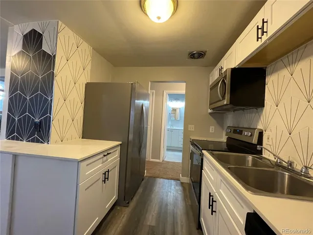 a kitchen that has a sink a stove and a refrigerator