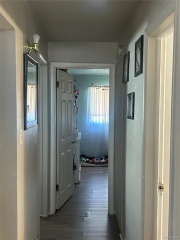 a view of a hallway with wooden floor and closet area