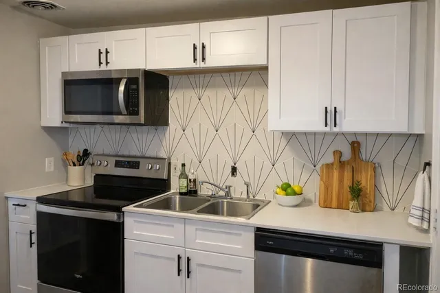a kitchen with stainless steel appliances a sink a stove and cabinets