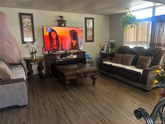 a living room with furniture a rug and a wooden floor