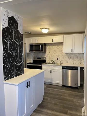 a kitchen with stainless steel appliances a stove a microwave and white cabinets