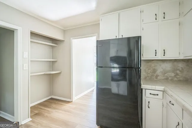 an empty room with wooden floor ceiling fan and windows