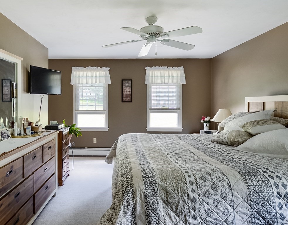 8 10 Rod Road Rutland, MA 01543 - Photo 16 of 32 a bedroom with a bed and a chandelier